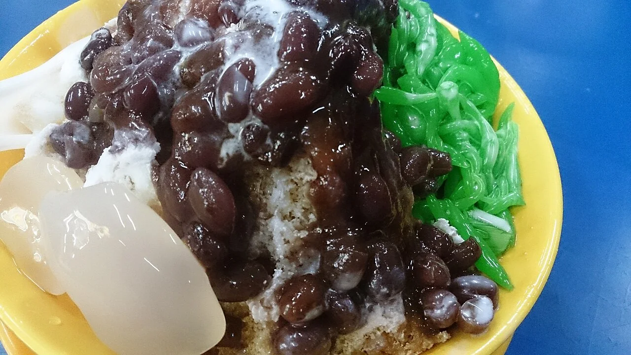 A bowl of chendol topped with red beans, green jelly and shaved ice.