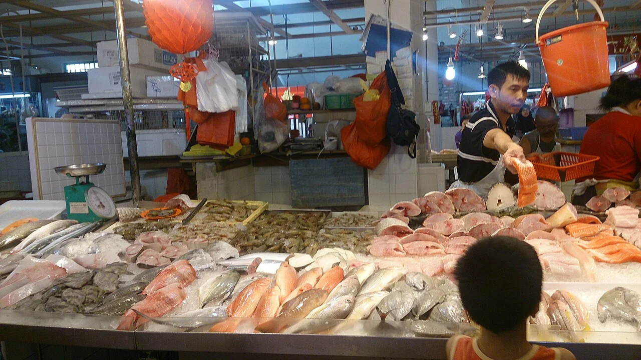 A wet market fish stall displaying various fresh fish and seafood on ice.