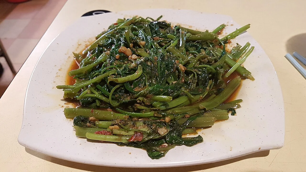 A plate of sambal kangkong, water spinach stir-fried with chili paste.