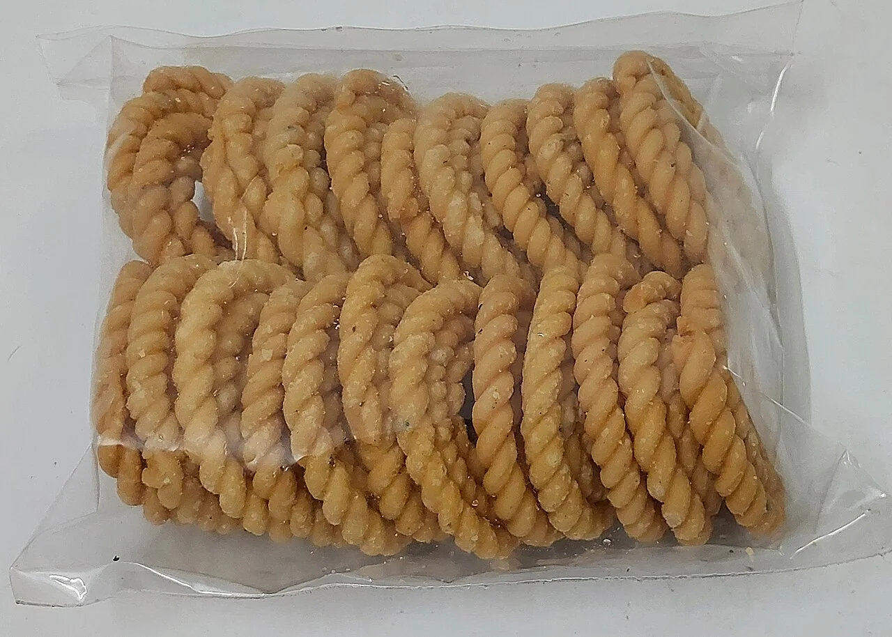 A clear plastic bag filled with coiled murukku snacks.
