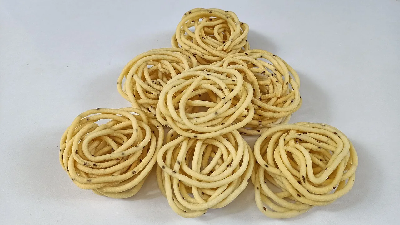 Several spiral-shaped murukku arranged on a plain surface.