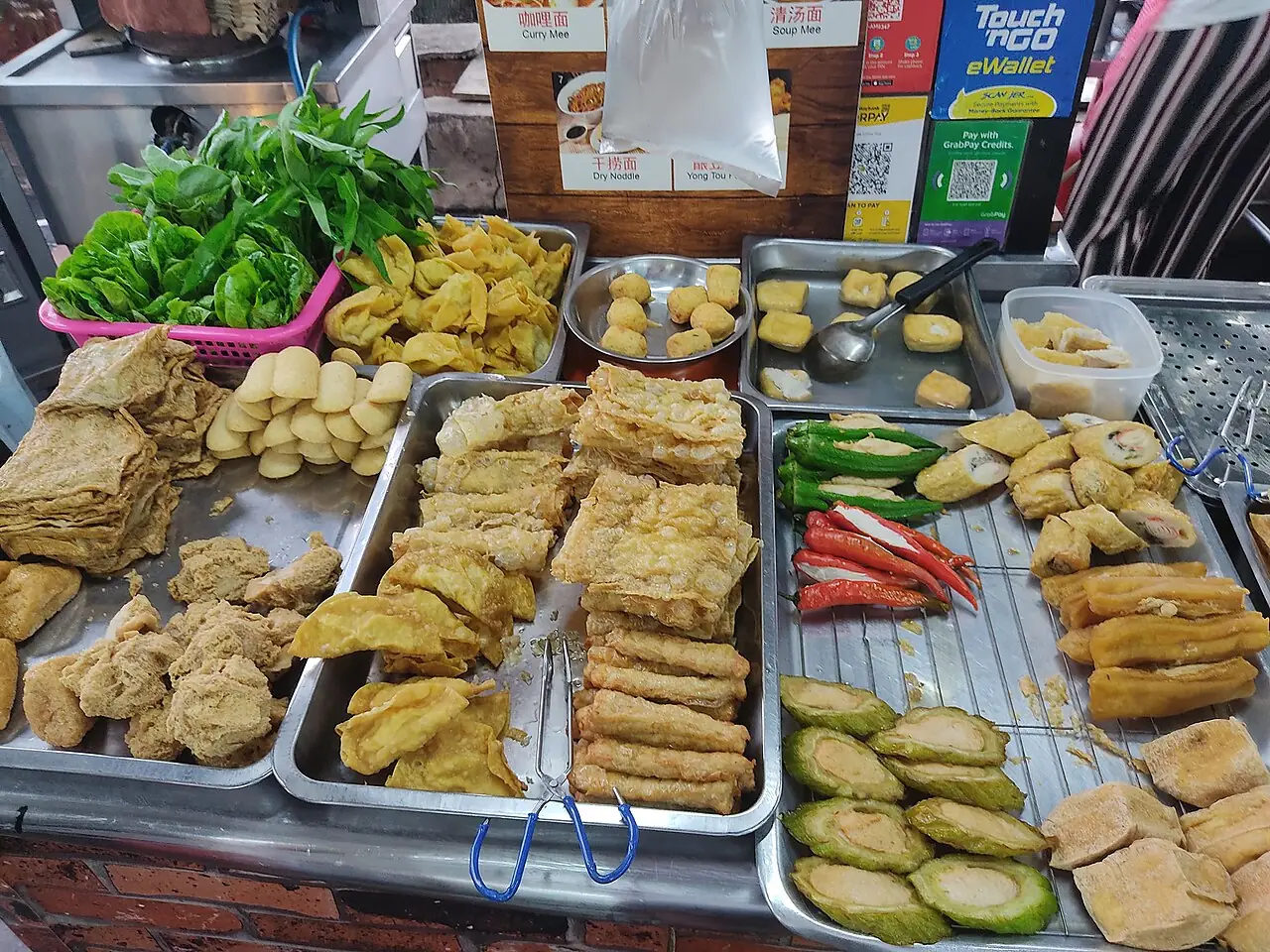 Trays of fried tofu, fishballs, stuffed vegetables and leafy greens are arranged at a yong tau foo stall.