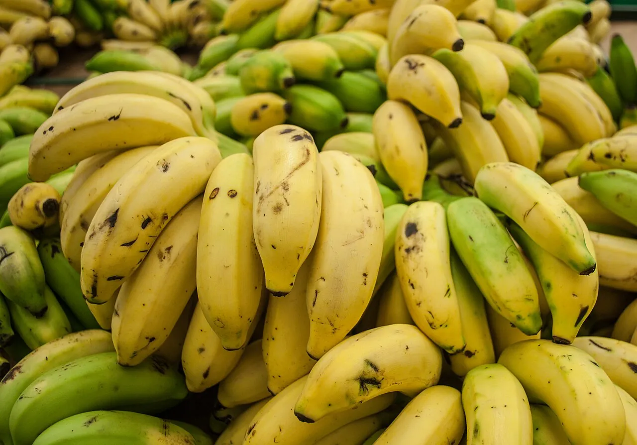 Banana — A pile of yellow bananas at a market stall.