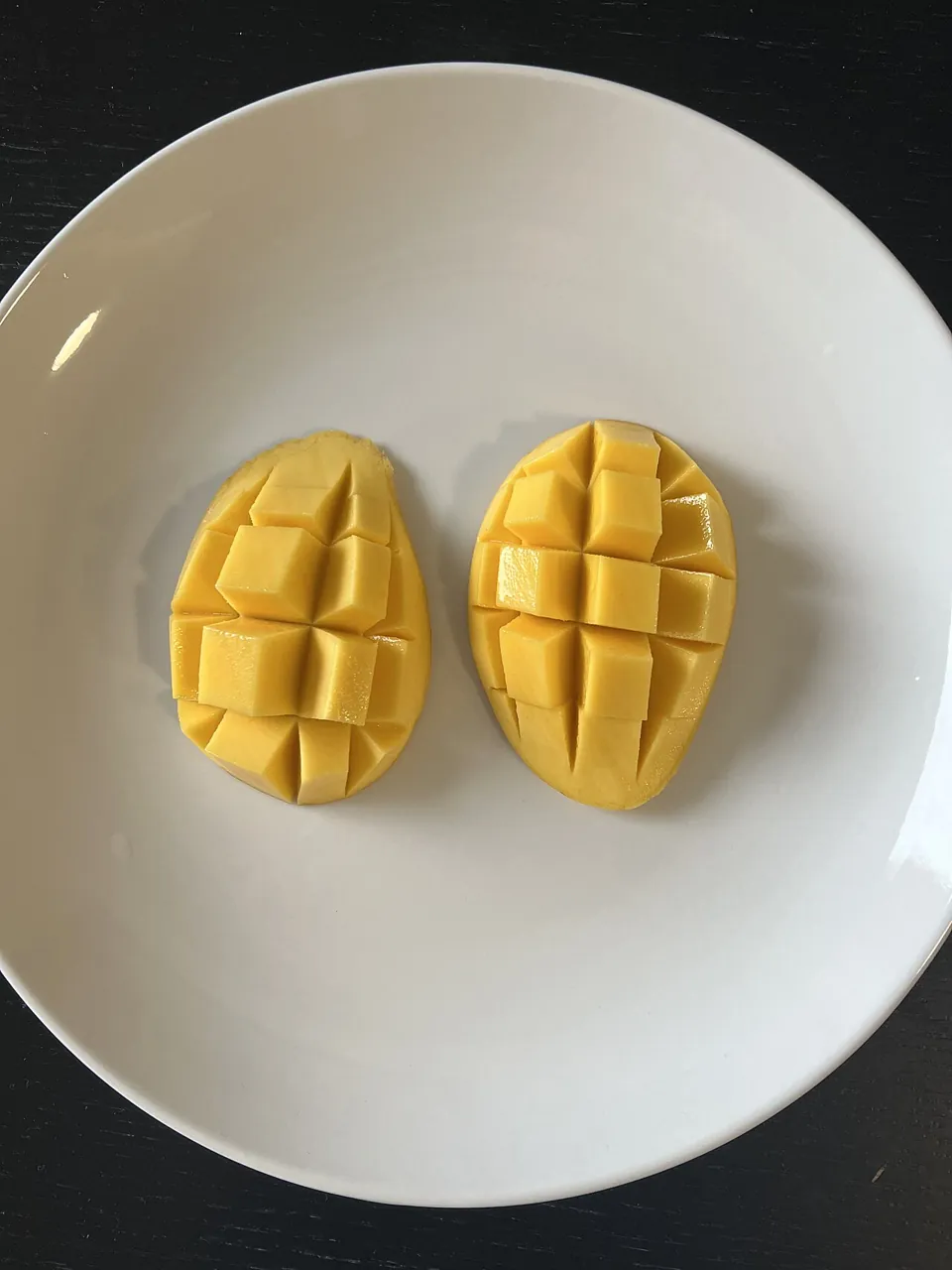 Mango — Mango cut into little squares on a plate.