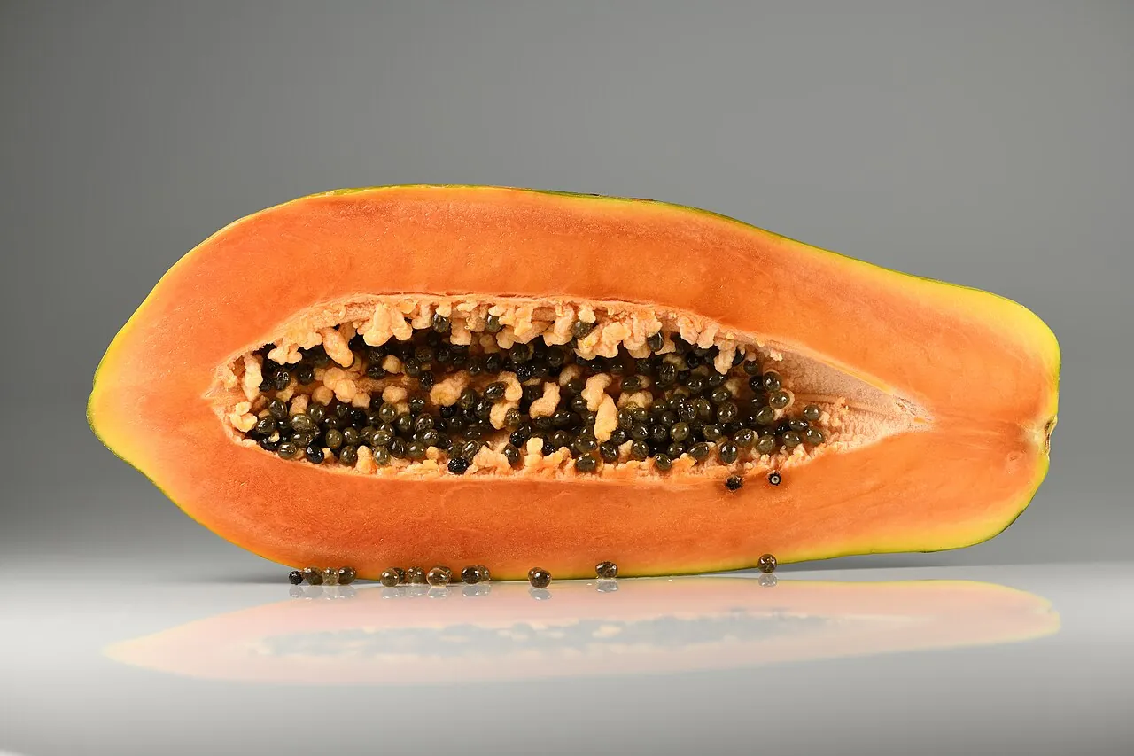 Papaya — A papaya cut in half, showing orange fruit and black seeds.