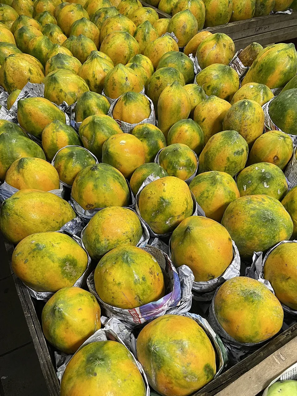 Papaya — Green and yellow papayas piled at a market.