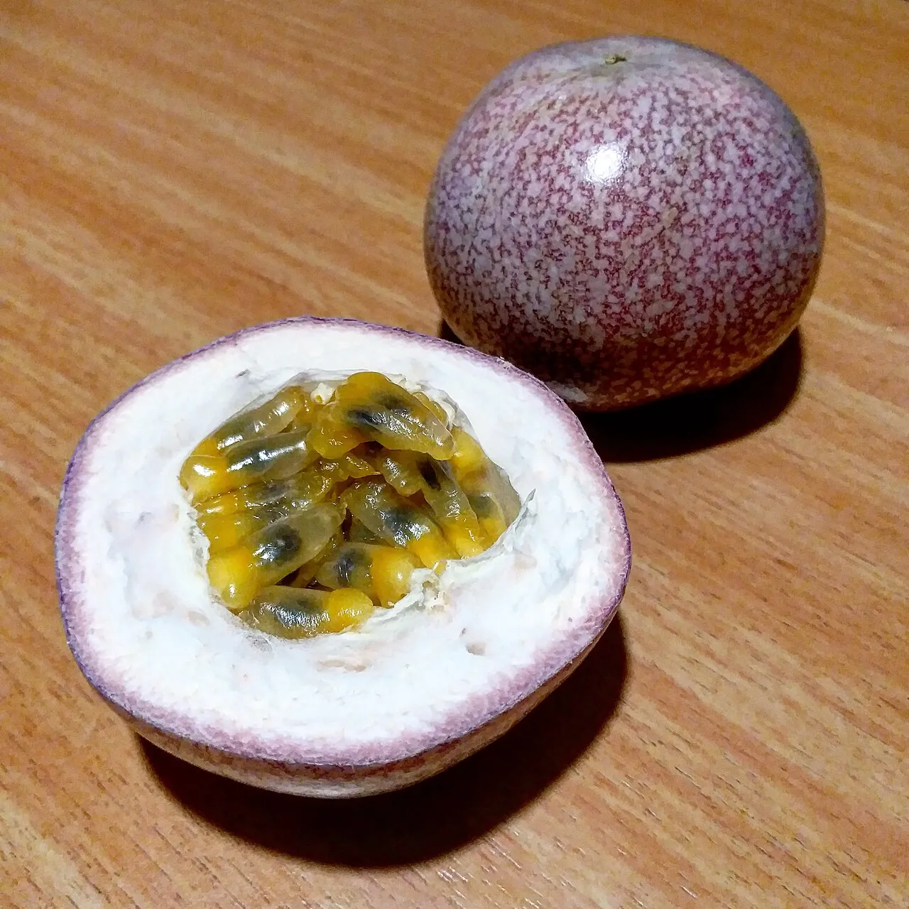 Passion fruit — A passion fruit cut in half, full of orange pulp and seeds.