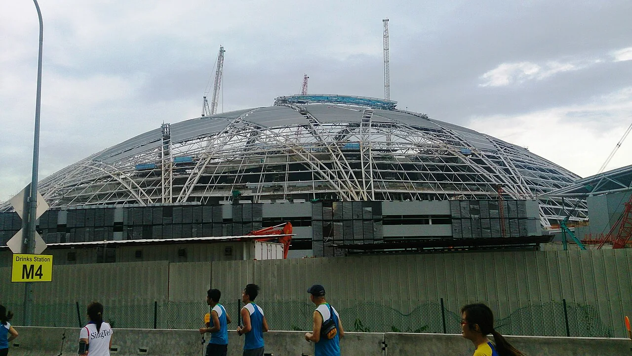 This 2013 photo shows cranes beside the exposed steel roof of Singapore’s National Stadium.