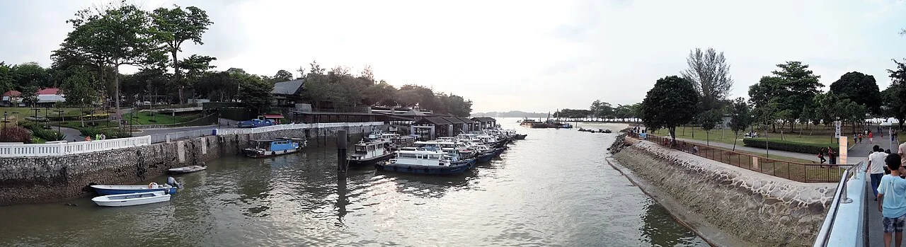 Small boats moored along the riverbank at Changi Point ferry terminal, with Changi Beach park on the right.