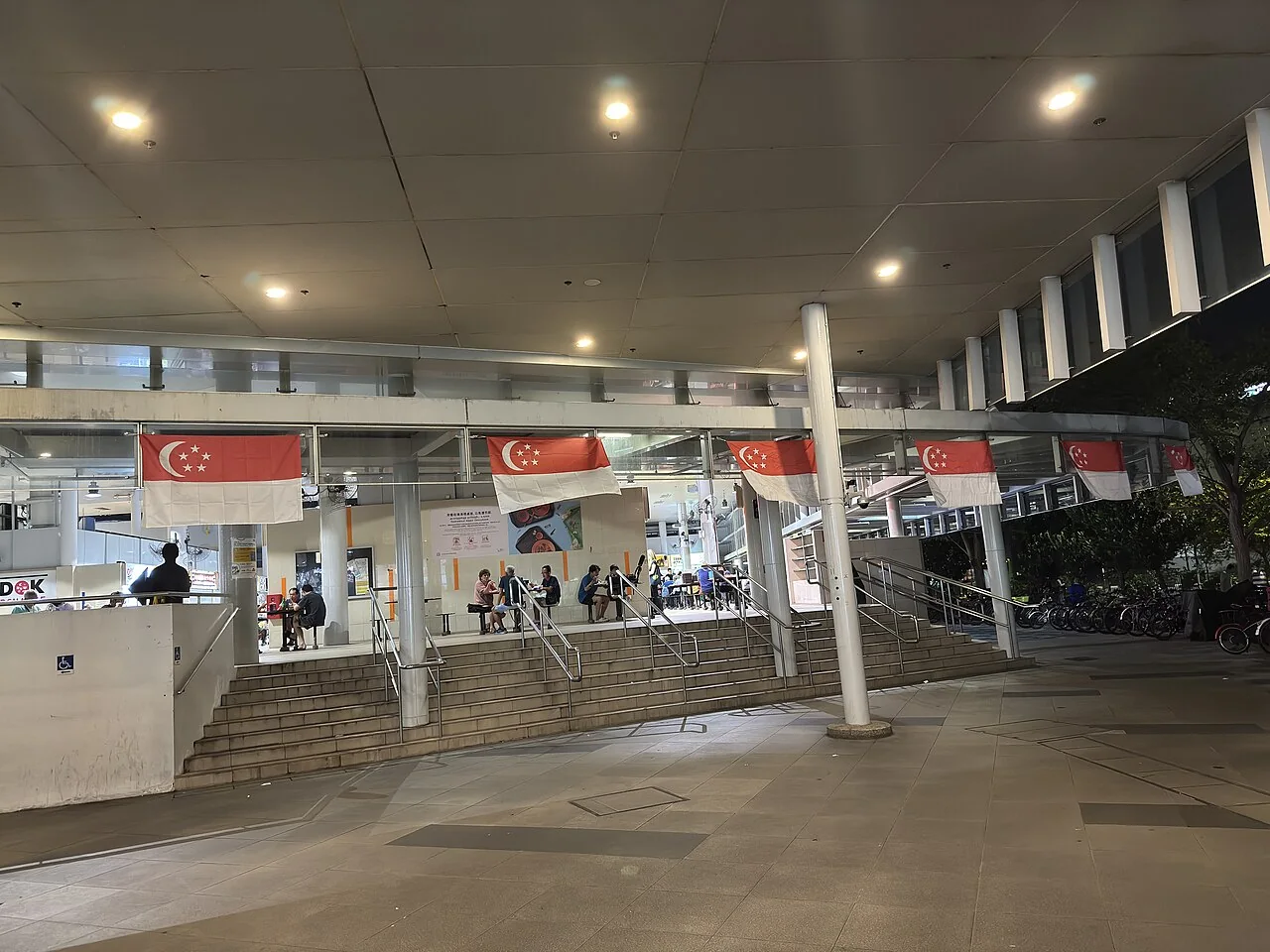 The entrance and open levels of a Singapore hawker centre are visible.