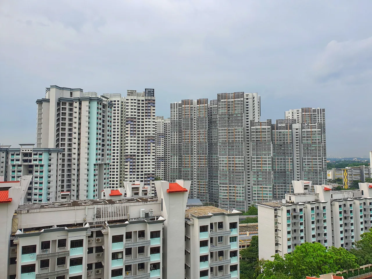 Tall HDB flats rise behind lower housing blocks.