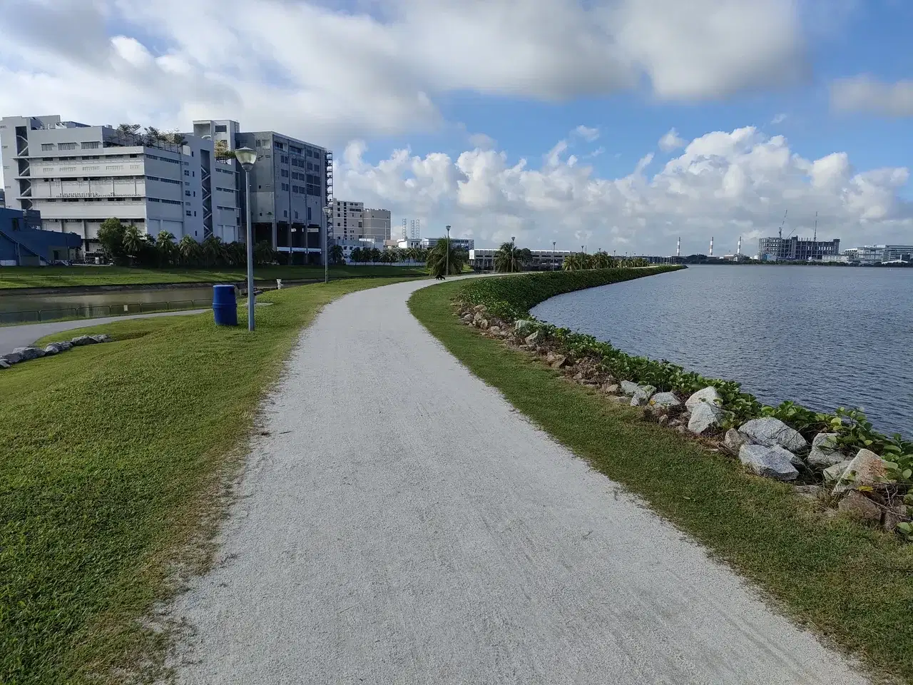 A curving path follows the reservoir beside grass and apartment blocks.