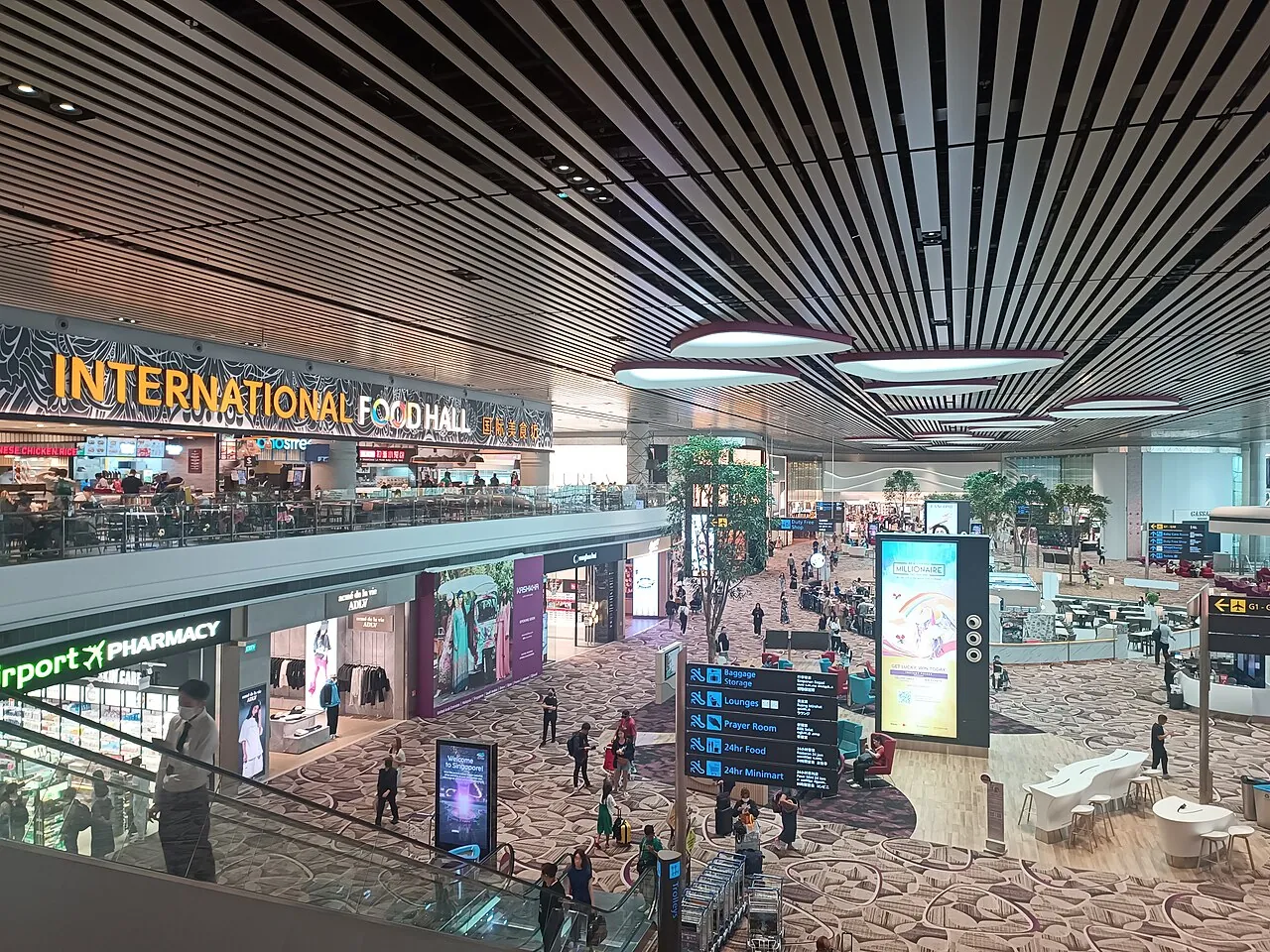 People walk through a large airport hall.
