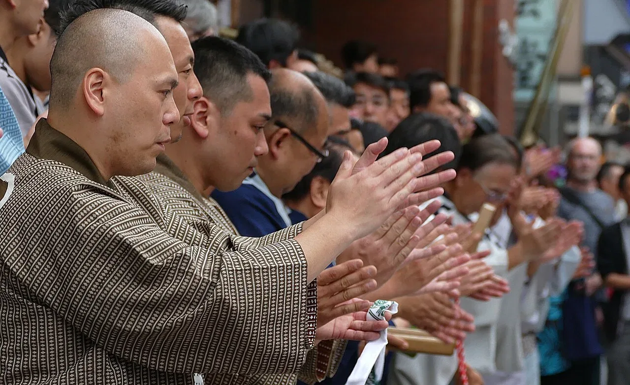 A crowd claps during a festival.