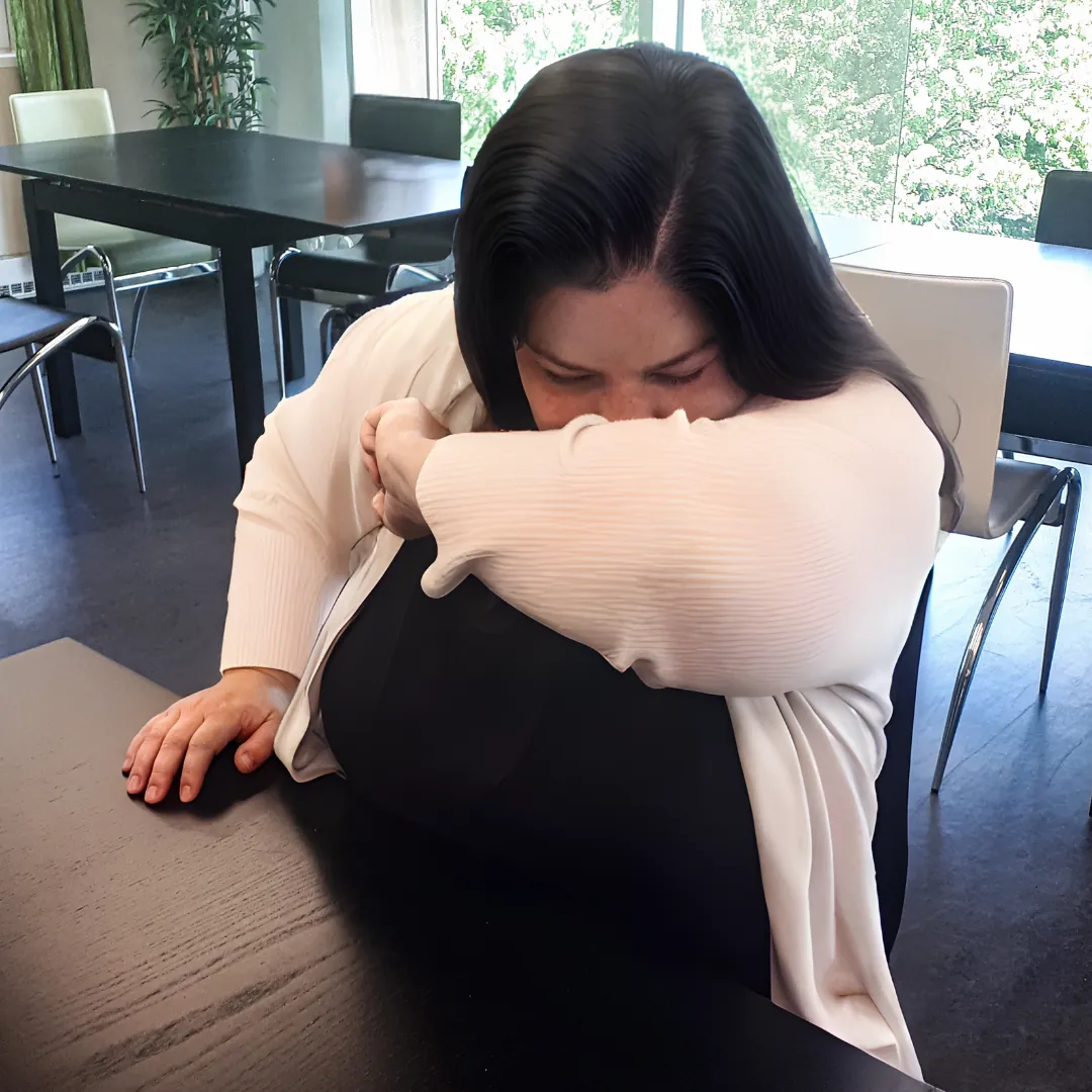A person coughs into their bent elbow.