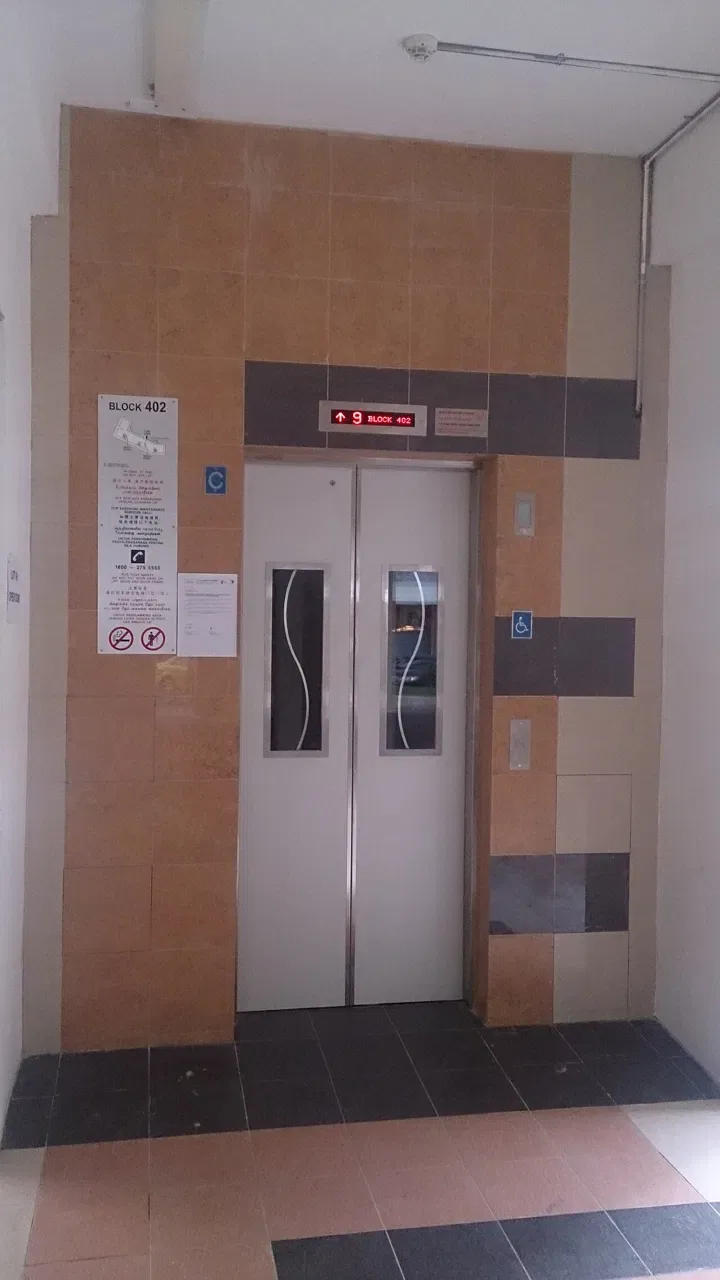 Closed lift doors stand beside a floor indicator and a Block402 sign.