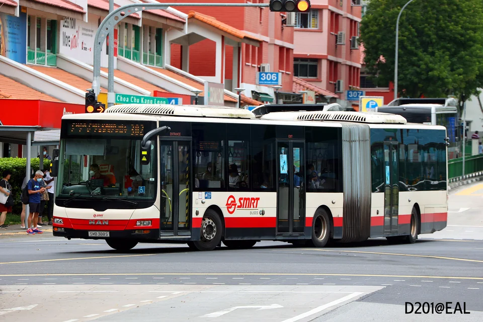 A red-and-white bendy bus is driving on a street.