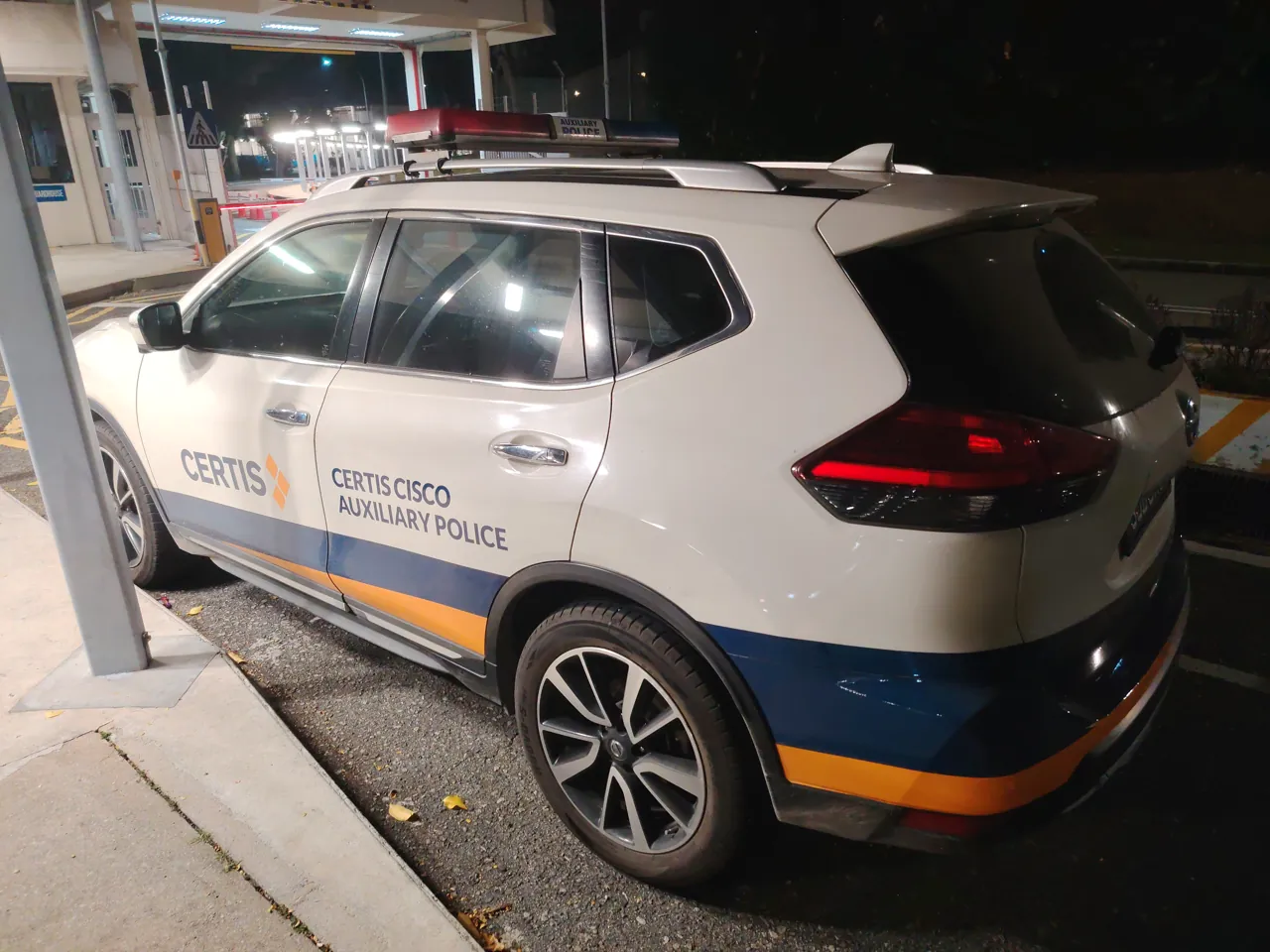 A white auxiliary police car has blue markings.
