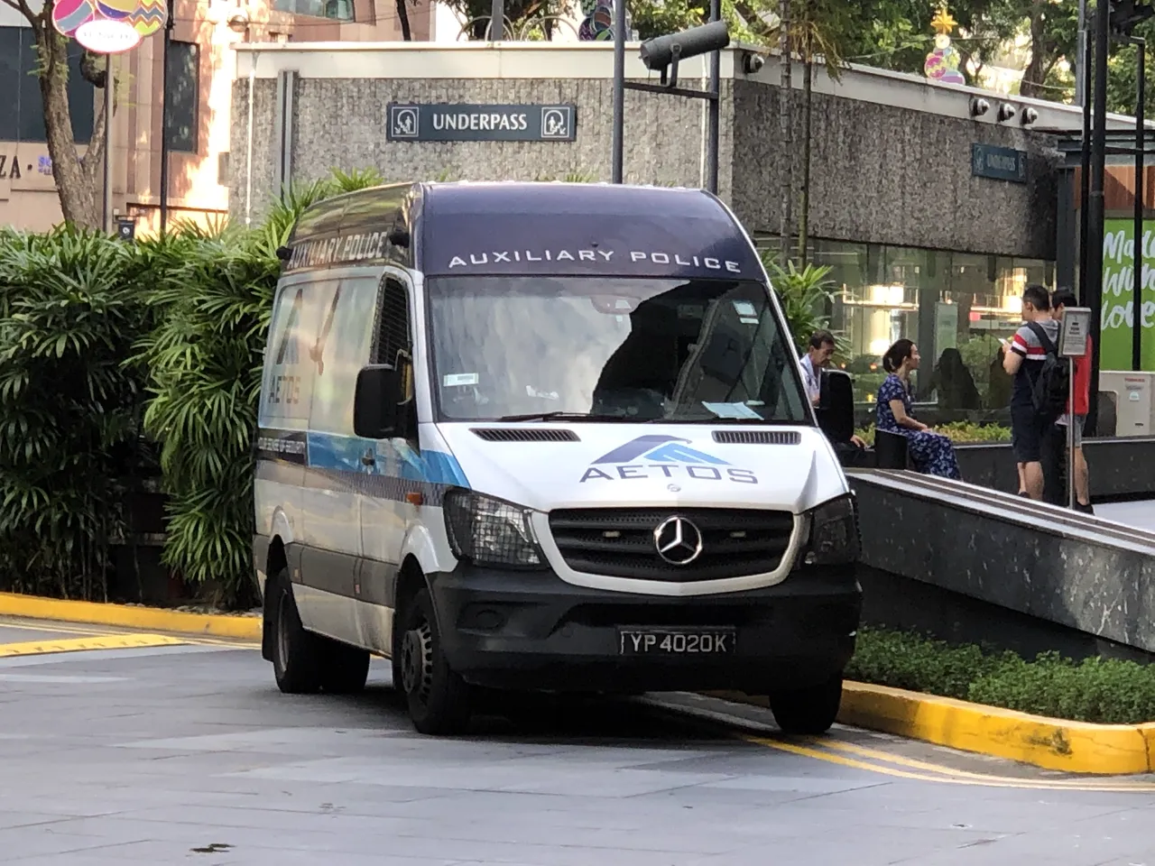 A white auxiliary police van is parked near a kerb.