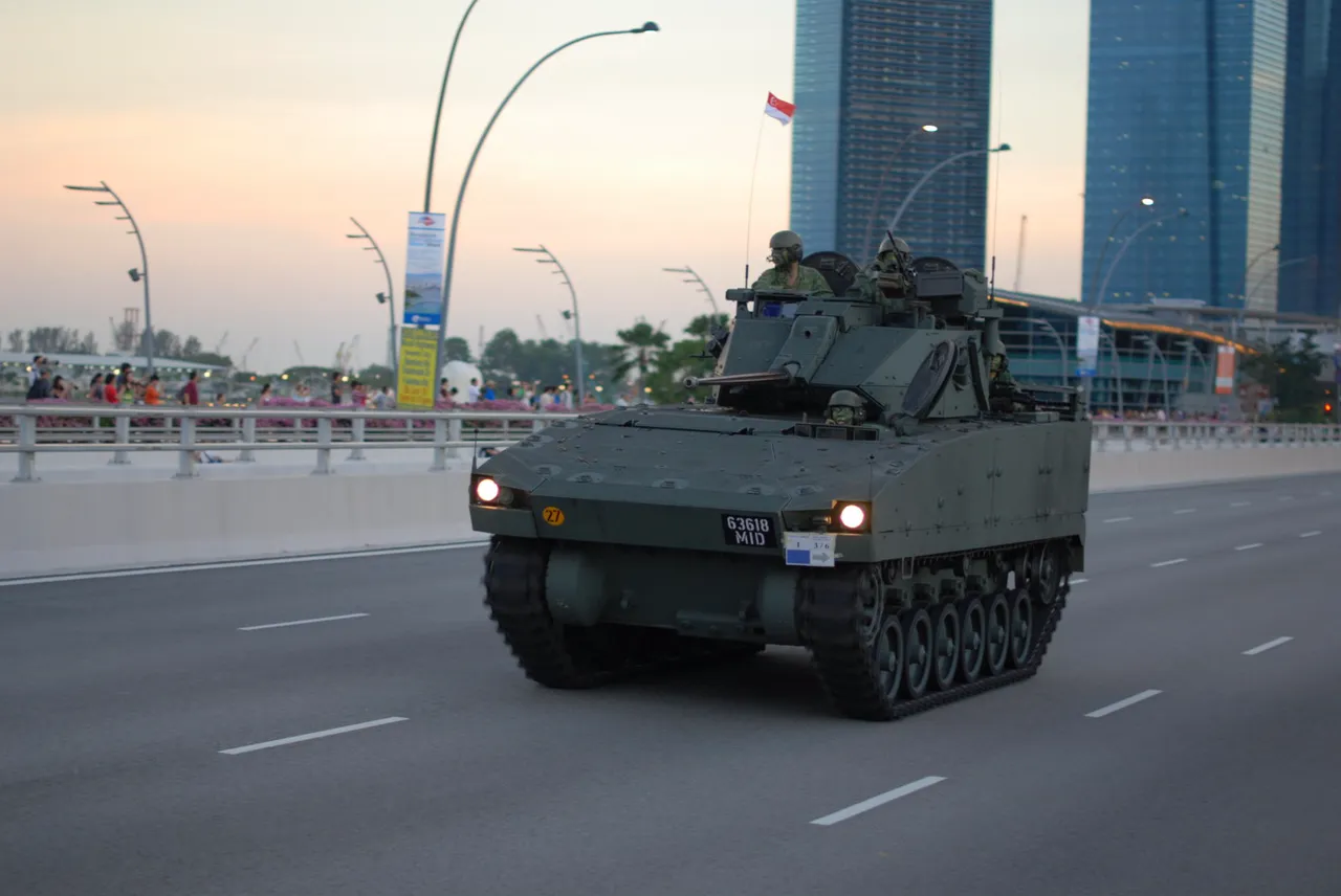 Tracked Bionix army carrier driving past crowds in Singapore.