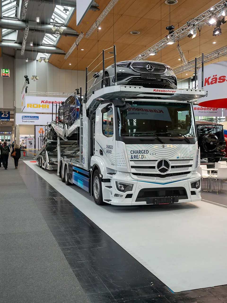 A car transporter carries cars on a raised upper platform.