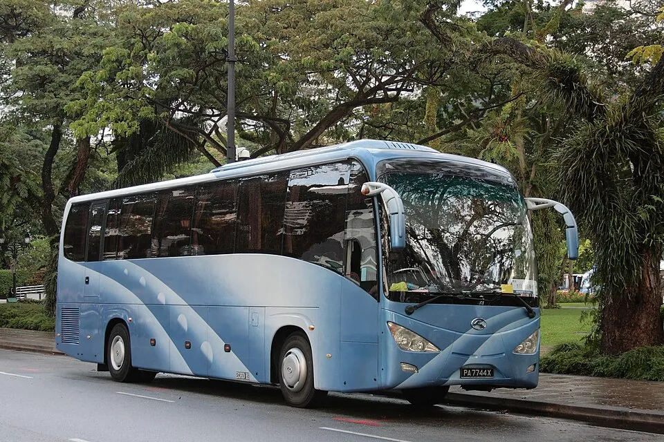 A blue coach with a wide windscreen and rows of side windows is shown from the front corner.