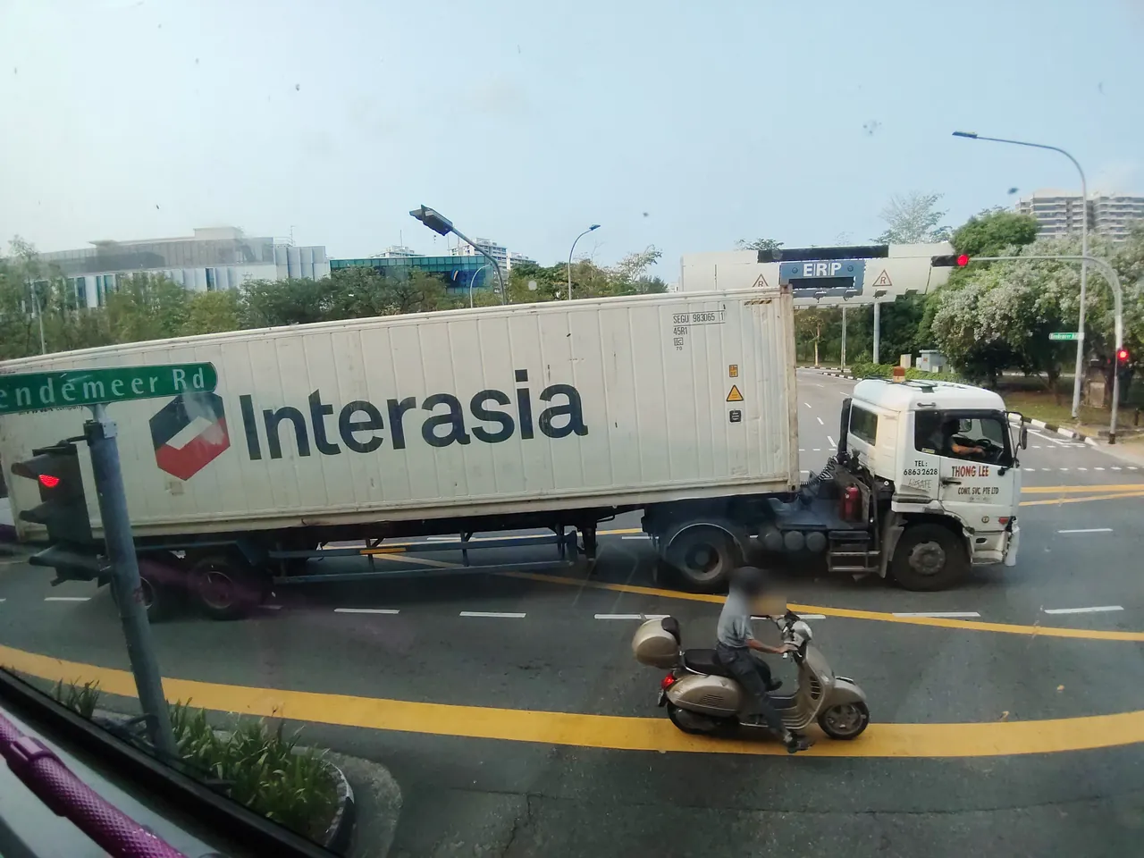 Container truck — a prime mover pulling a long white container across a junction, photographed in Singapore