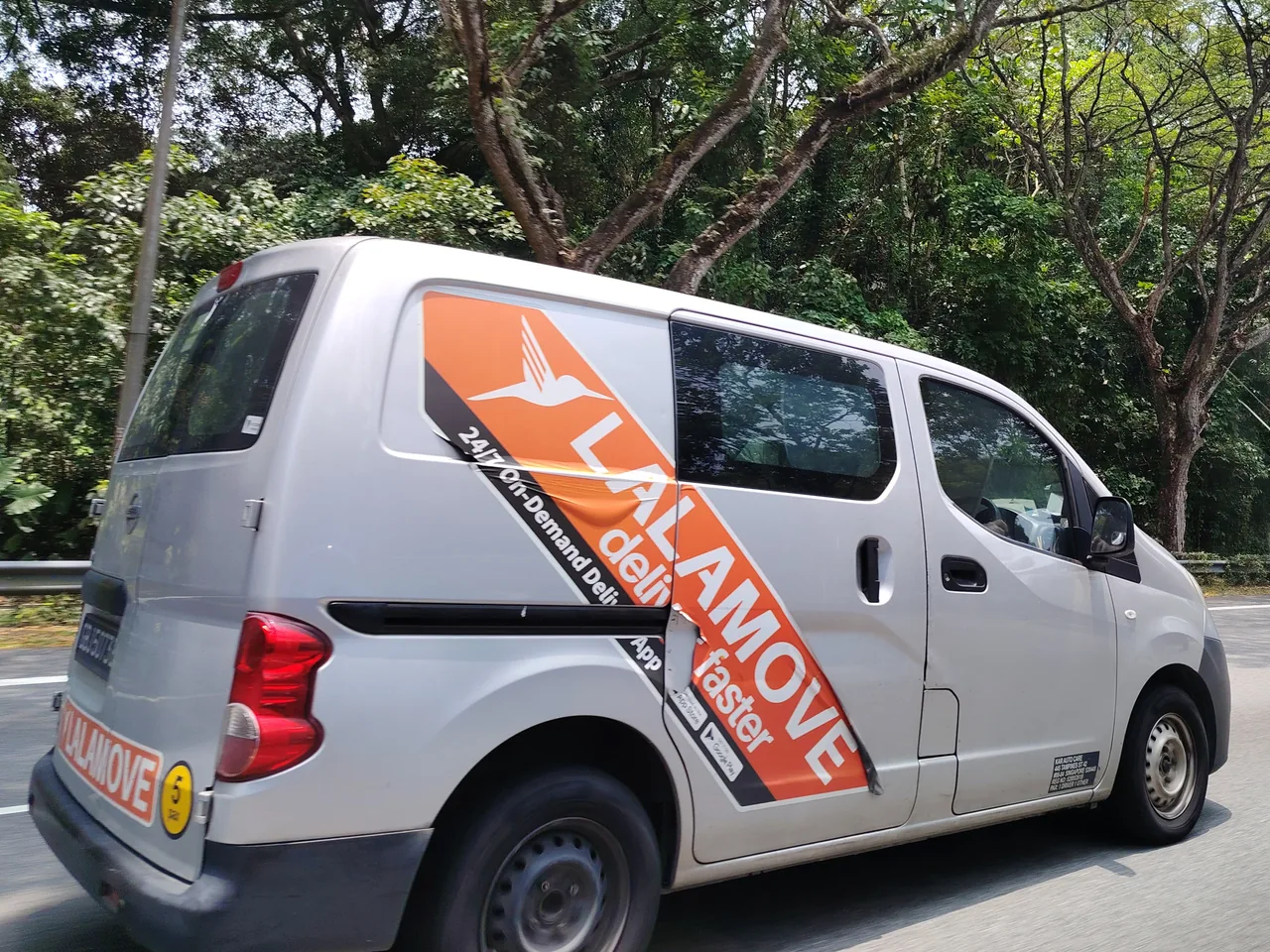 Delivery van — a silver delivery van with a wide orange stripe across its side, Photographed in Singapore