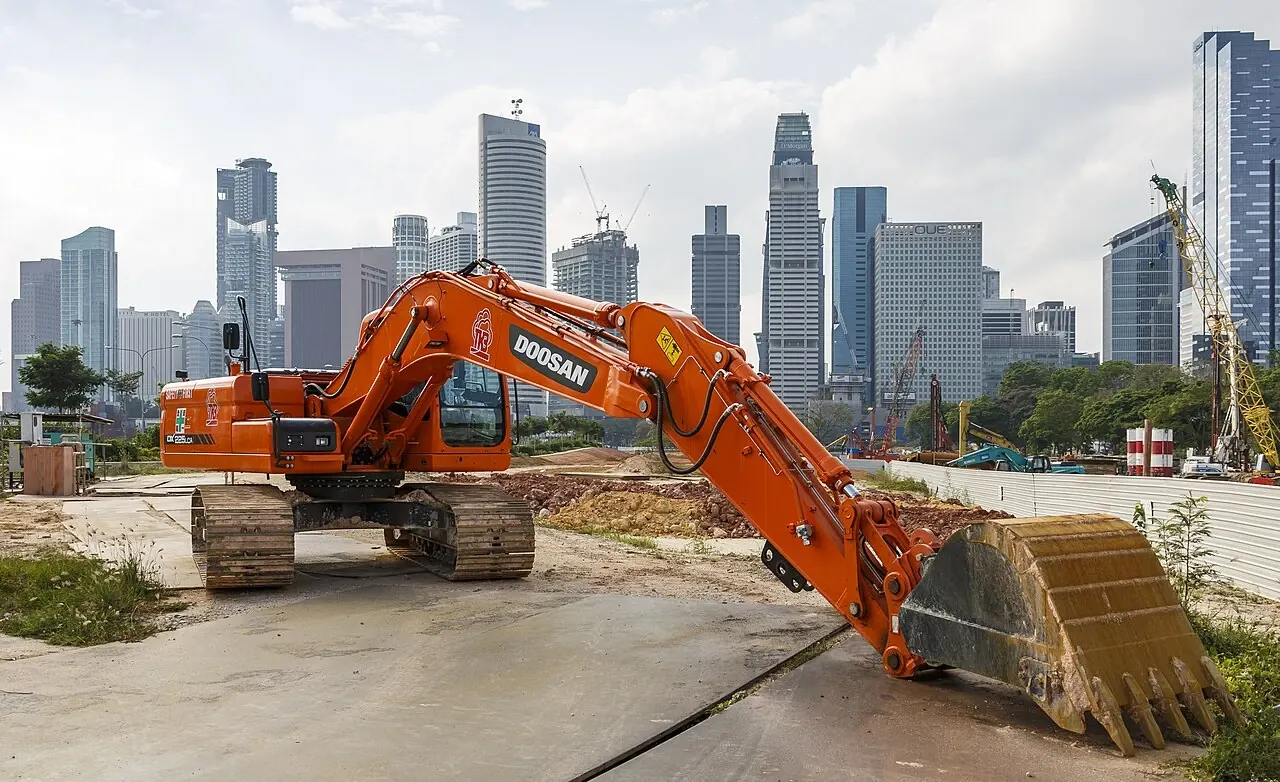 Doosan excavator at a work site in front of the Singapore skyline.