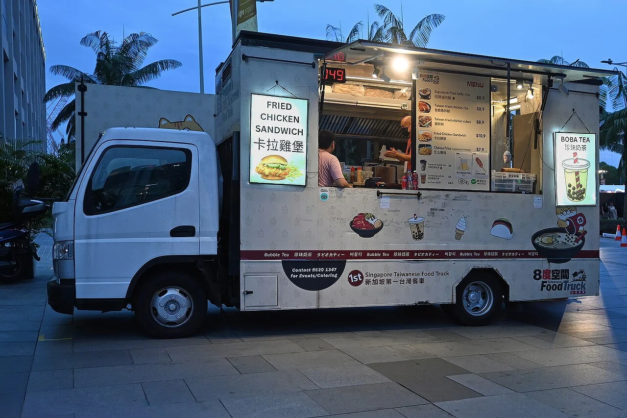 A white food truck with an open serving window at Marina Bay, Singapore.
