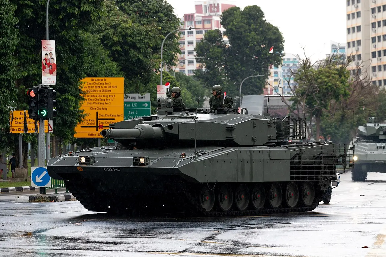 A Leopard tank travels along a wet city road.