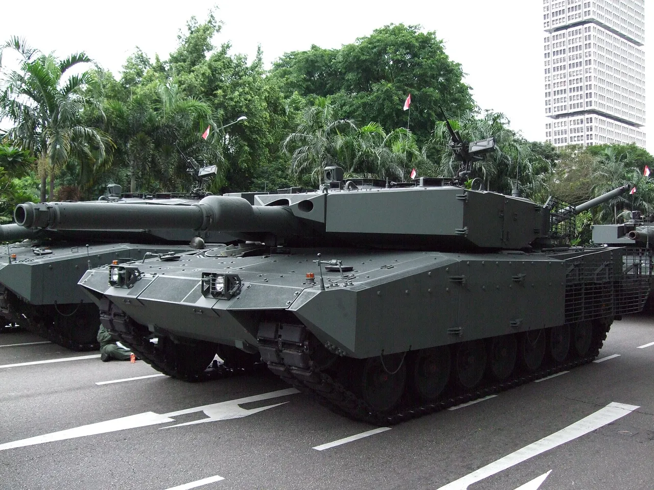 A dark green tank has wide tracks and a long barrel pointing forward.