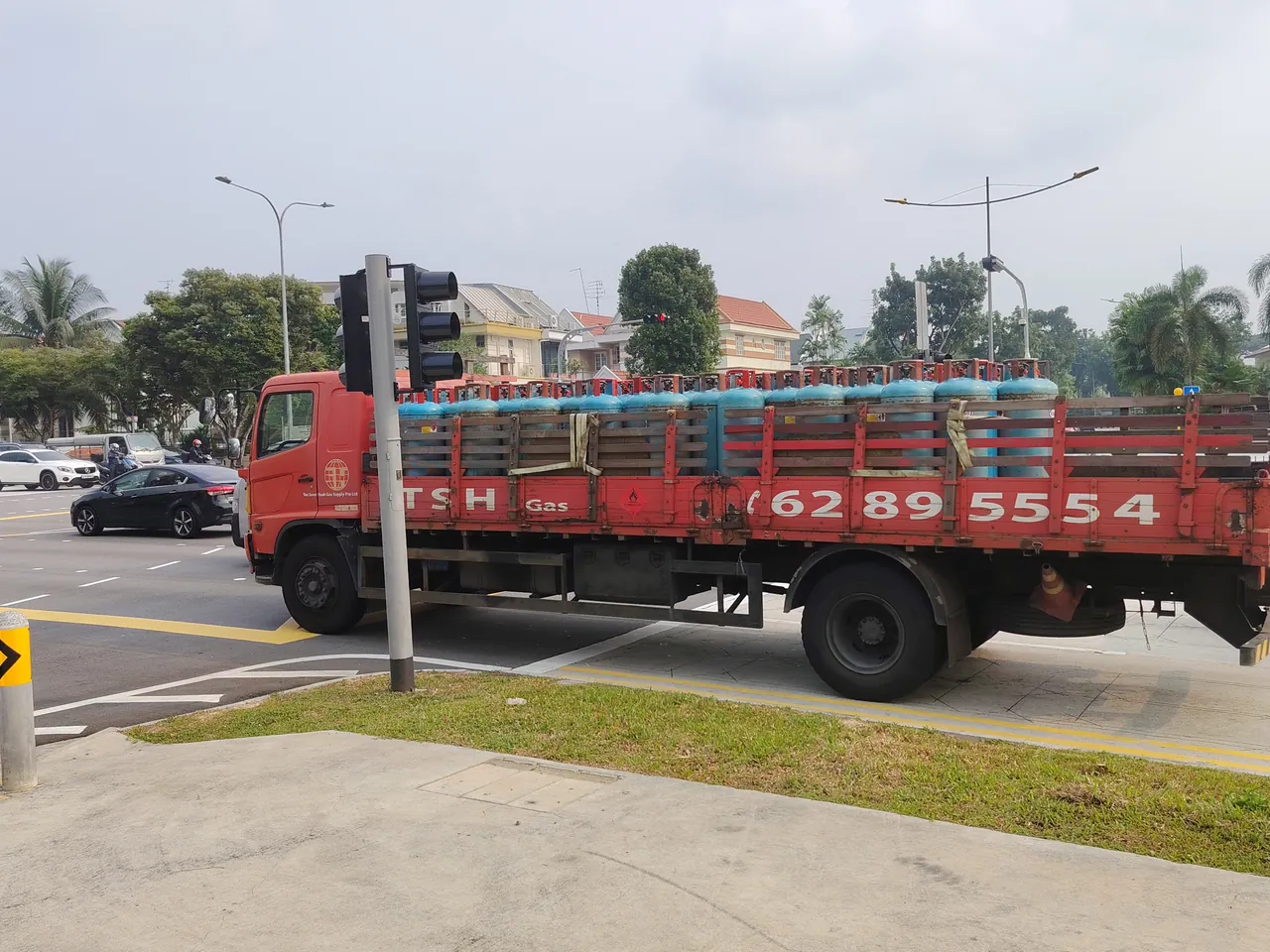 LPG cylinder truck — a red flatbed loaded with gas cylinders, photographed in Singapore