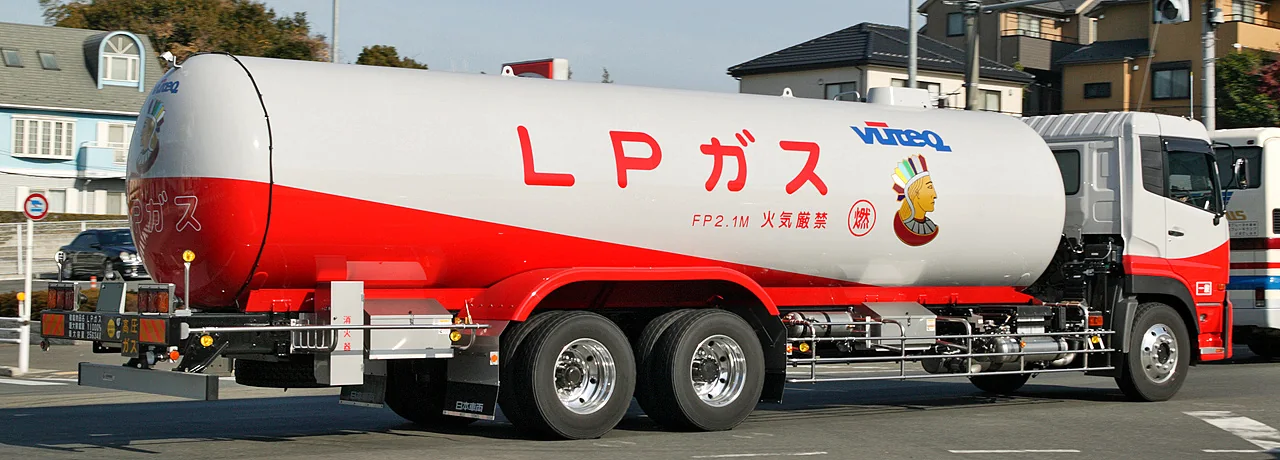 A red-and-white LPG truck has a large tank marked LP gas.