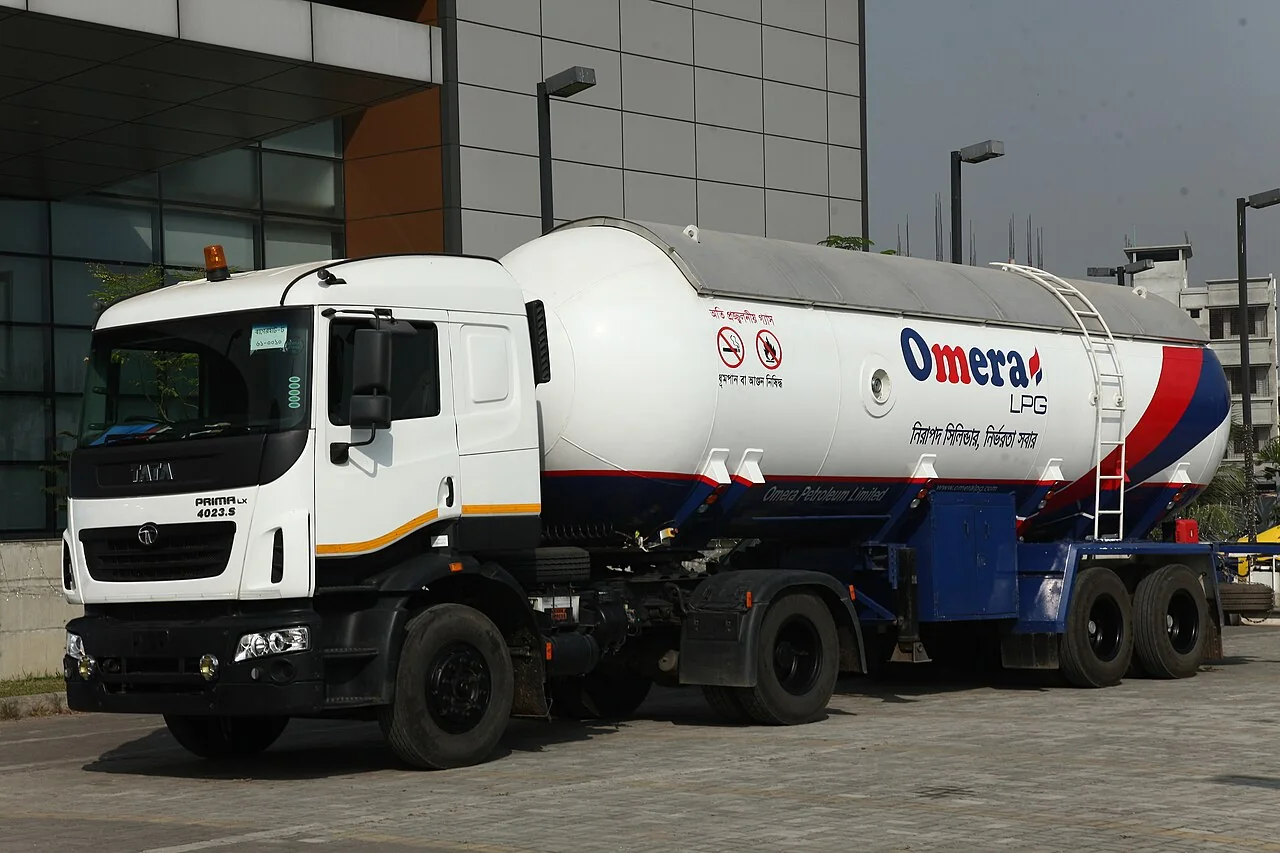 A white Omera LPG truck has a long tank trailer behind its cab.