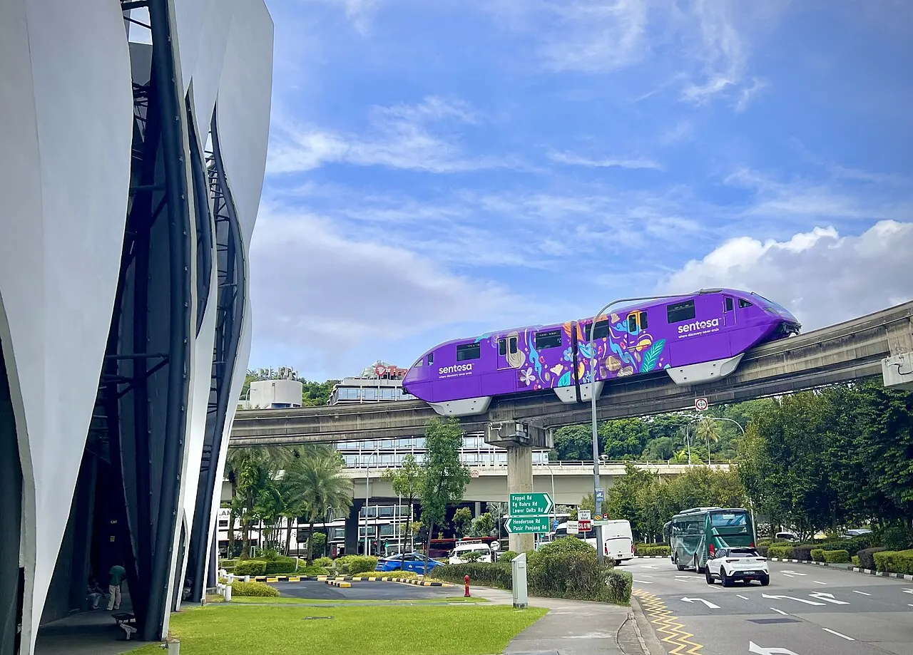 A purple monorail travels on a raised concrete guideway.