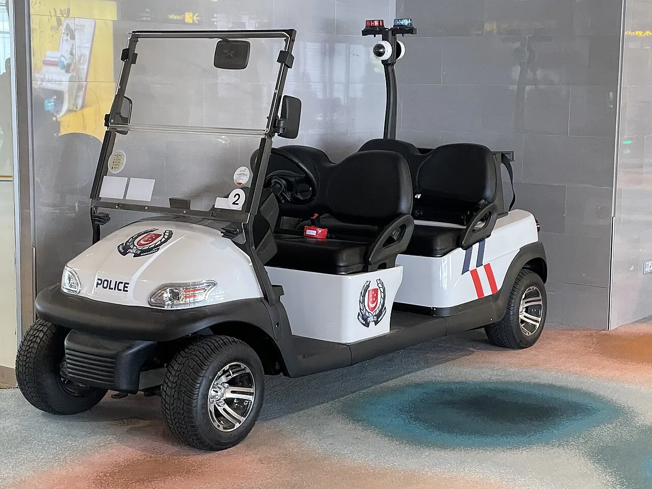 A small white patrol buggy has an open side.