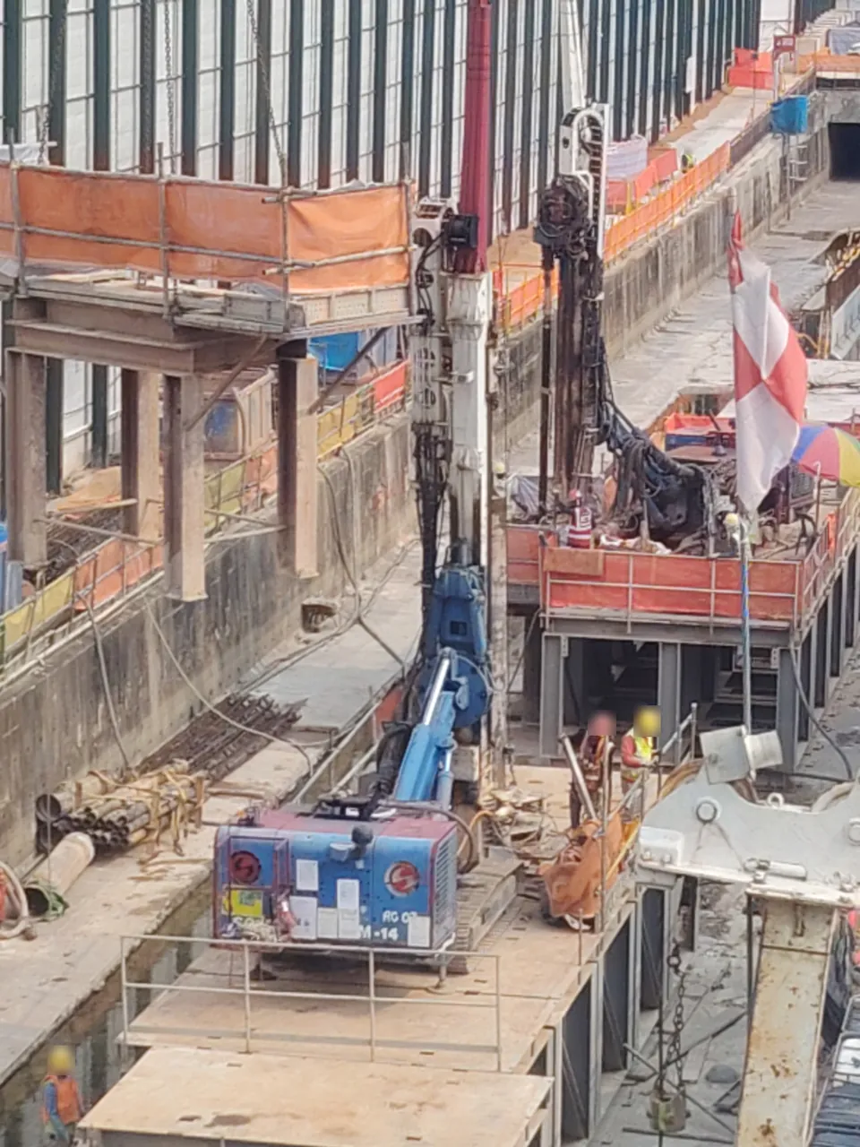 Piling rig — a piling rig with a tall mast standing in a deep excavation.