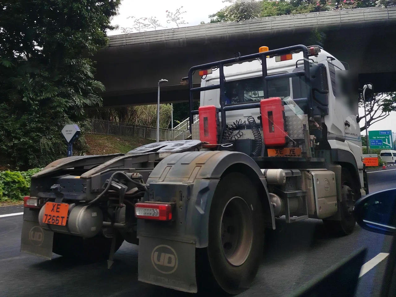 Prime mover — a white prime mover driving along a road with no trailer behind it, Photographed in Singapore