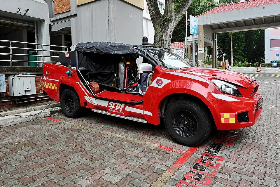 A red emergency buggy has an open side and flashing lights.