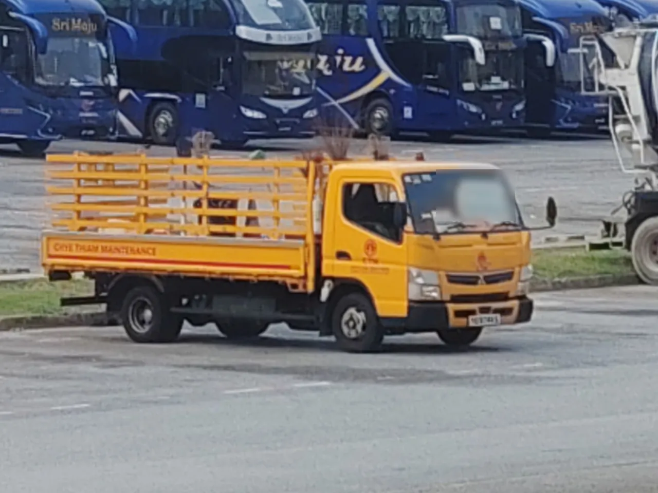Refuse truck — a yellow lorry with tall yellow bars around its back.