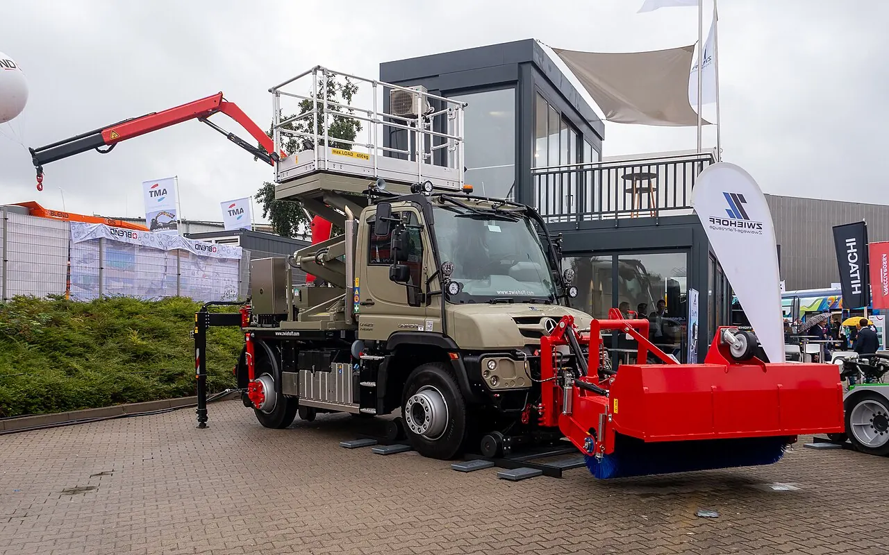 A road-rail maintenance truck carries a raised platform and red equipment.