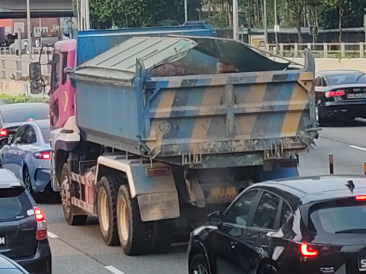 Tipper truck — a loaded tipper truck with its cover pulled over, photographed in Singapore