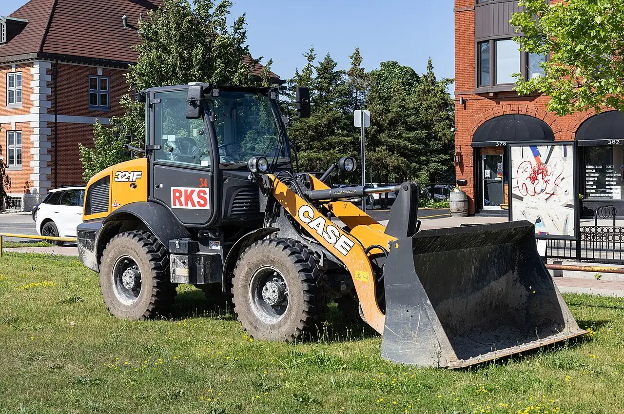 A yellow wheel loader has four large tyres and a wide front bucket.